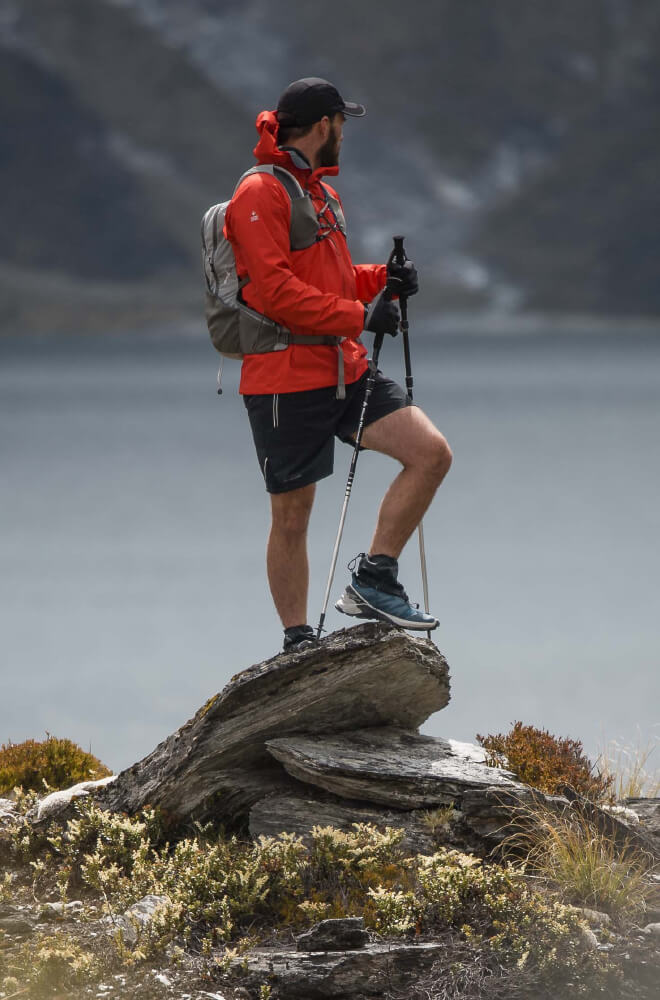 Mountain biker wearing Macpac pack riding down rocks