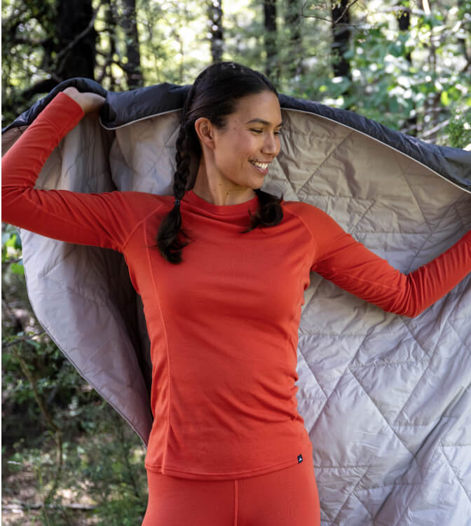 Women wearing macpac papaya thermal and holding a jacket