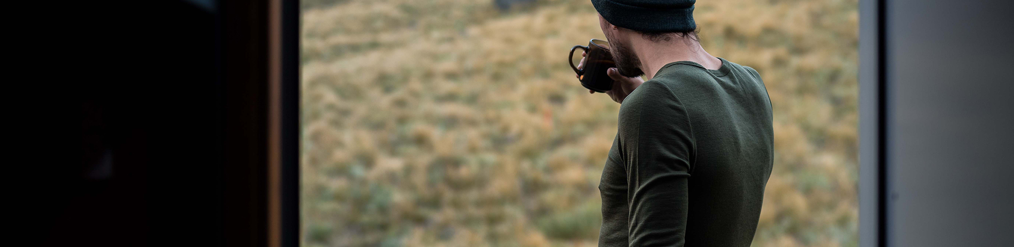 Person wearing grey/peach coloured merino baselayers in a backcountry hut