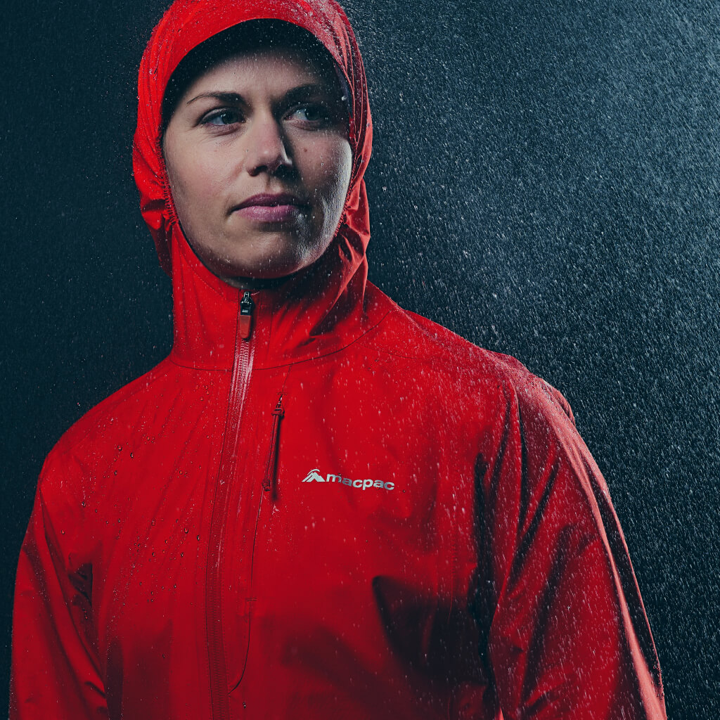 Person standing in Red Tempo Rain Jacket at night in heavy rain