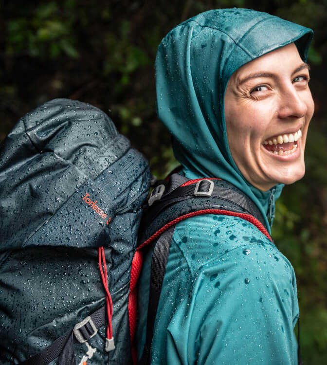 Smiling person wearing green macpac rain jacket
