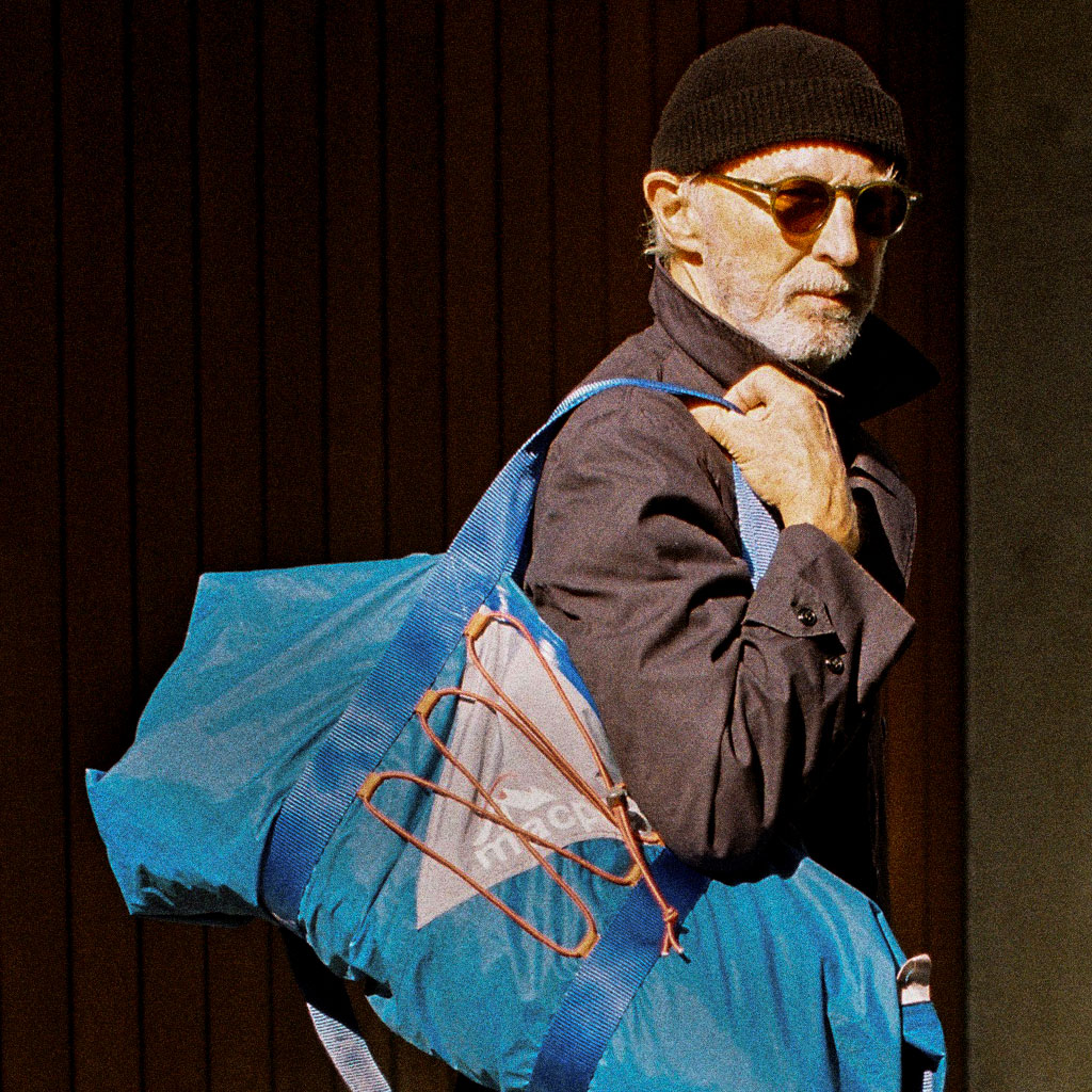 Old man with Macpac duffel bag on his shoulder